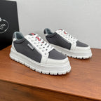 Prada unisex sneakers, front side view: gray mesh upper, white leather panels, red tag