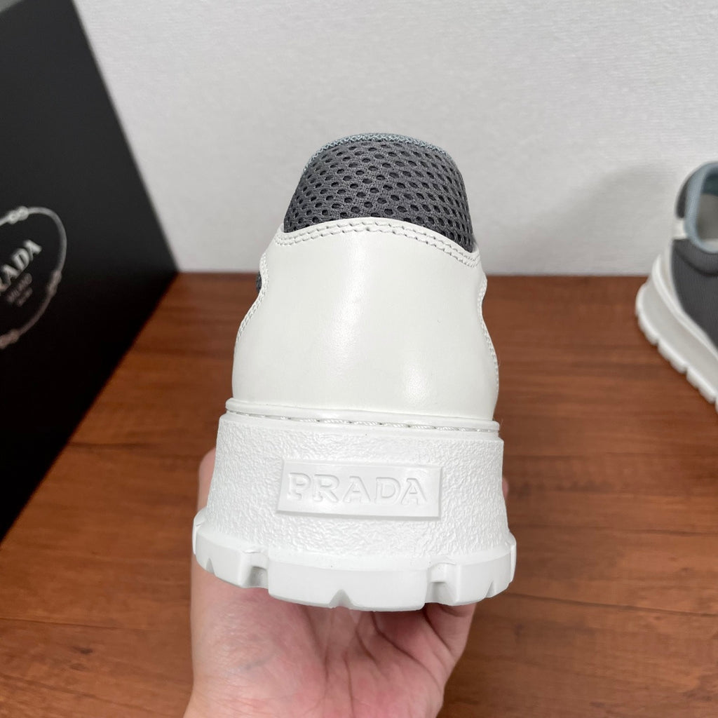 Prada unisex sneakers heel view: gray mesh back, white heel with PRADA embossed