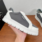 Prada unisex sneakers, hand-held side view: gray mesh, white leather trim, thick sole