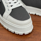 Prada unisex sneakers close-up sole: white rubber tread, gray upper with white panel