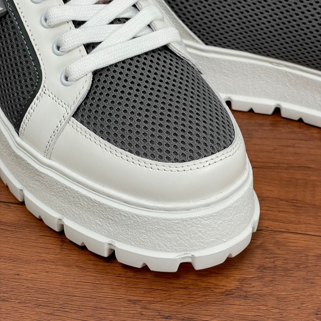 Prada unisex sneakers close-up sole: white rubber tread, gray upper with white panel