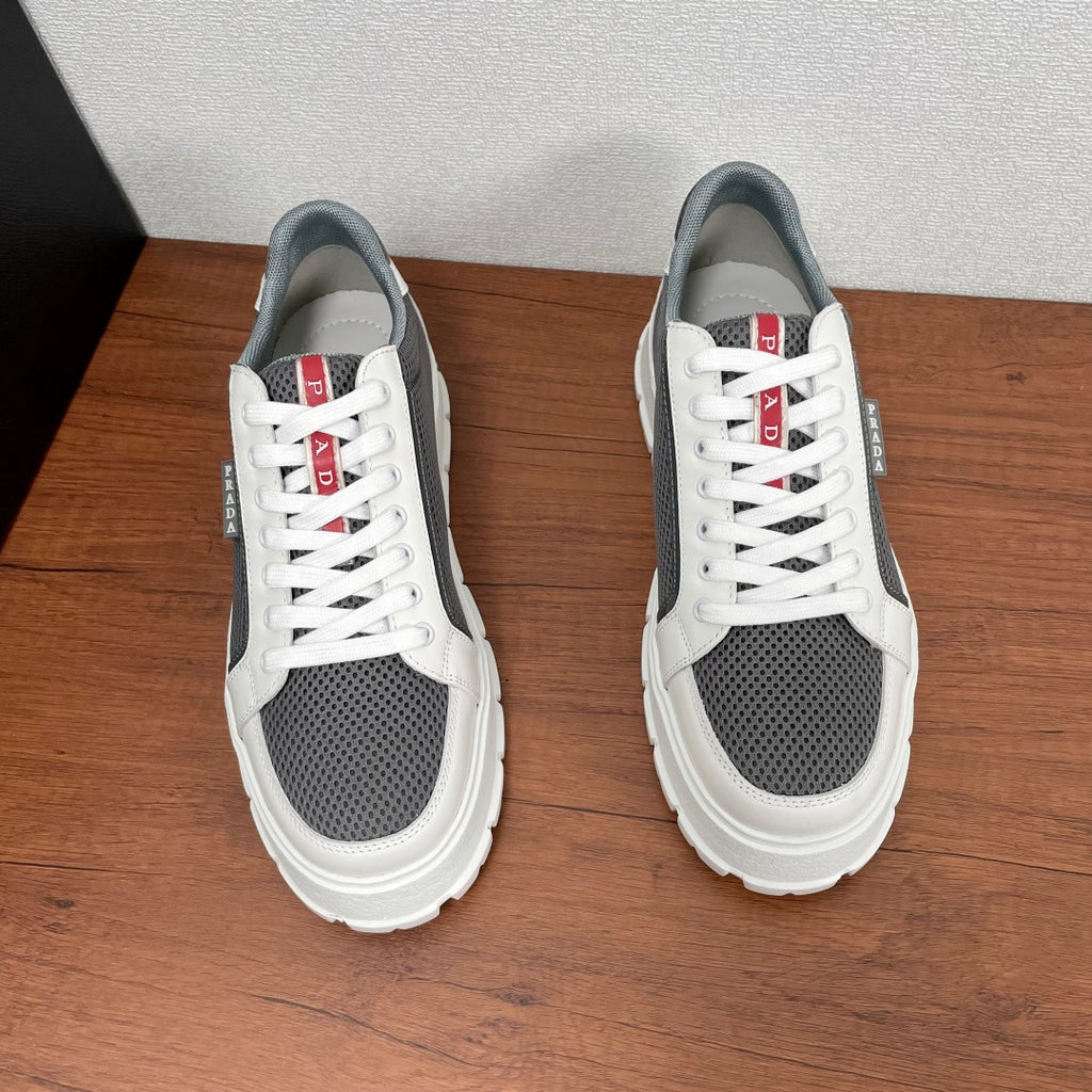 Prada unisex sneakers pair, side view: white laces, gray mesh panels, chunky sole