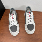 Prada unisex sneakers pair, side view: white laces, gray mesh panels, chunky sole