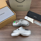 Pair of silver slip-on clogs with molded strap and decorative charm details