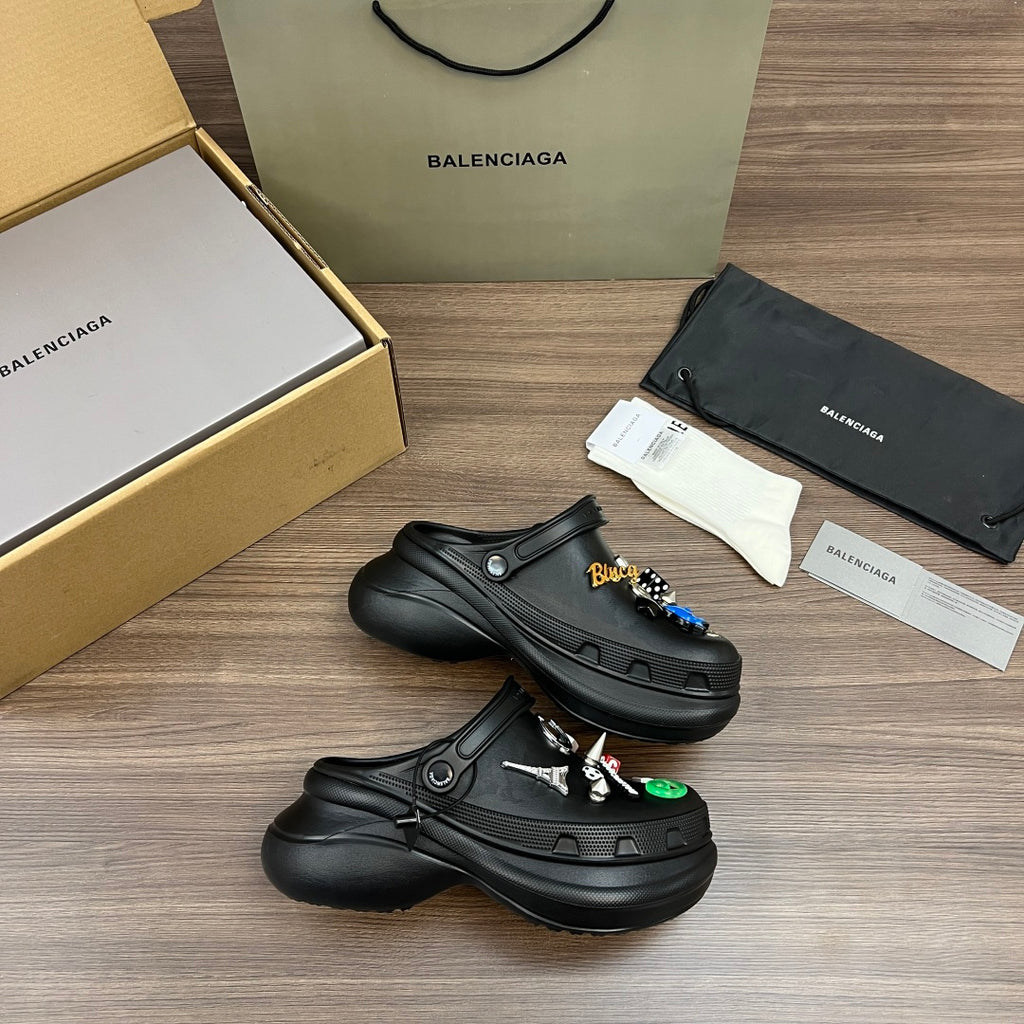 Black Balenciaga sandals with side button detail and decorative charm patches