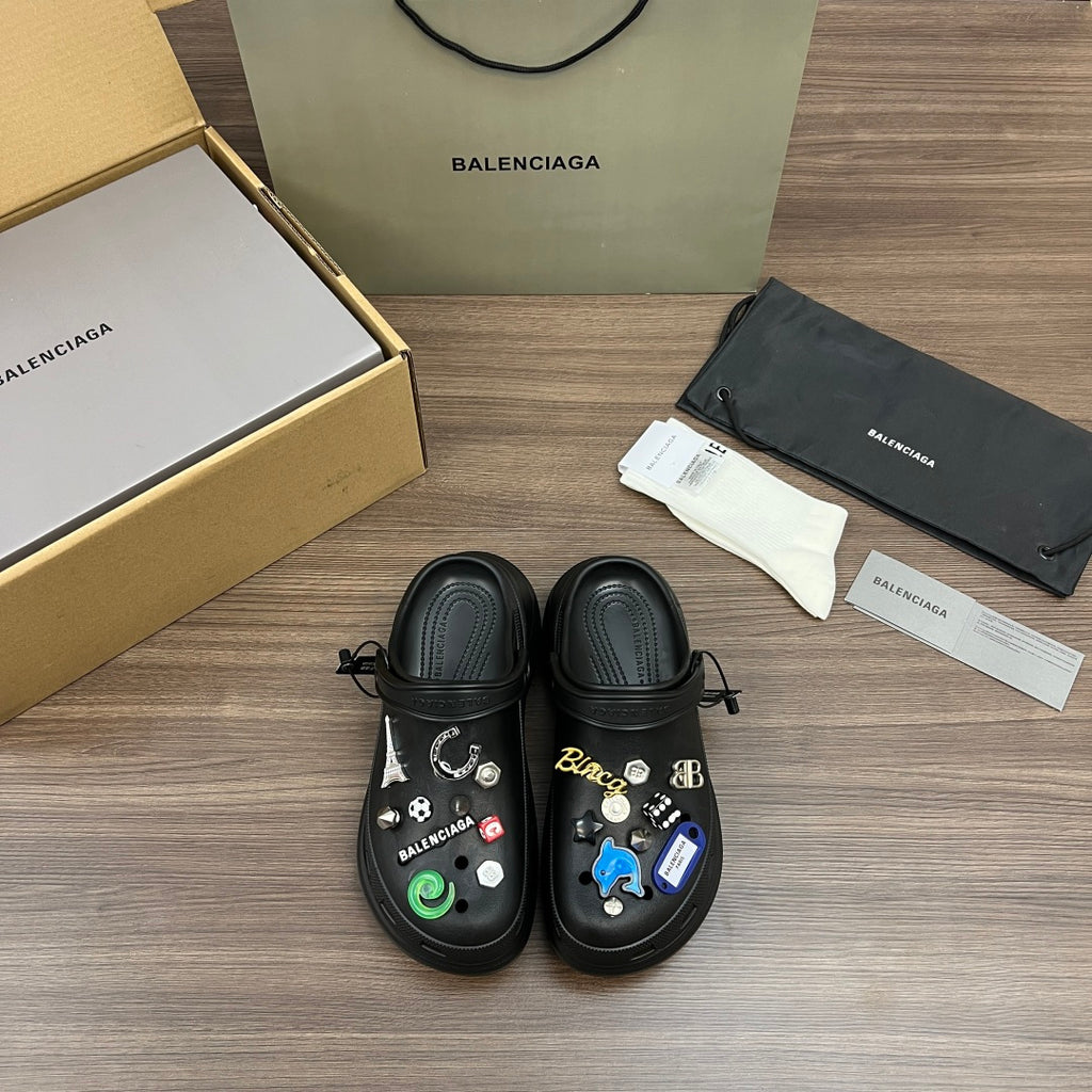 Black Balenciaga sandals with lace-up straps and decorative charms on top