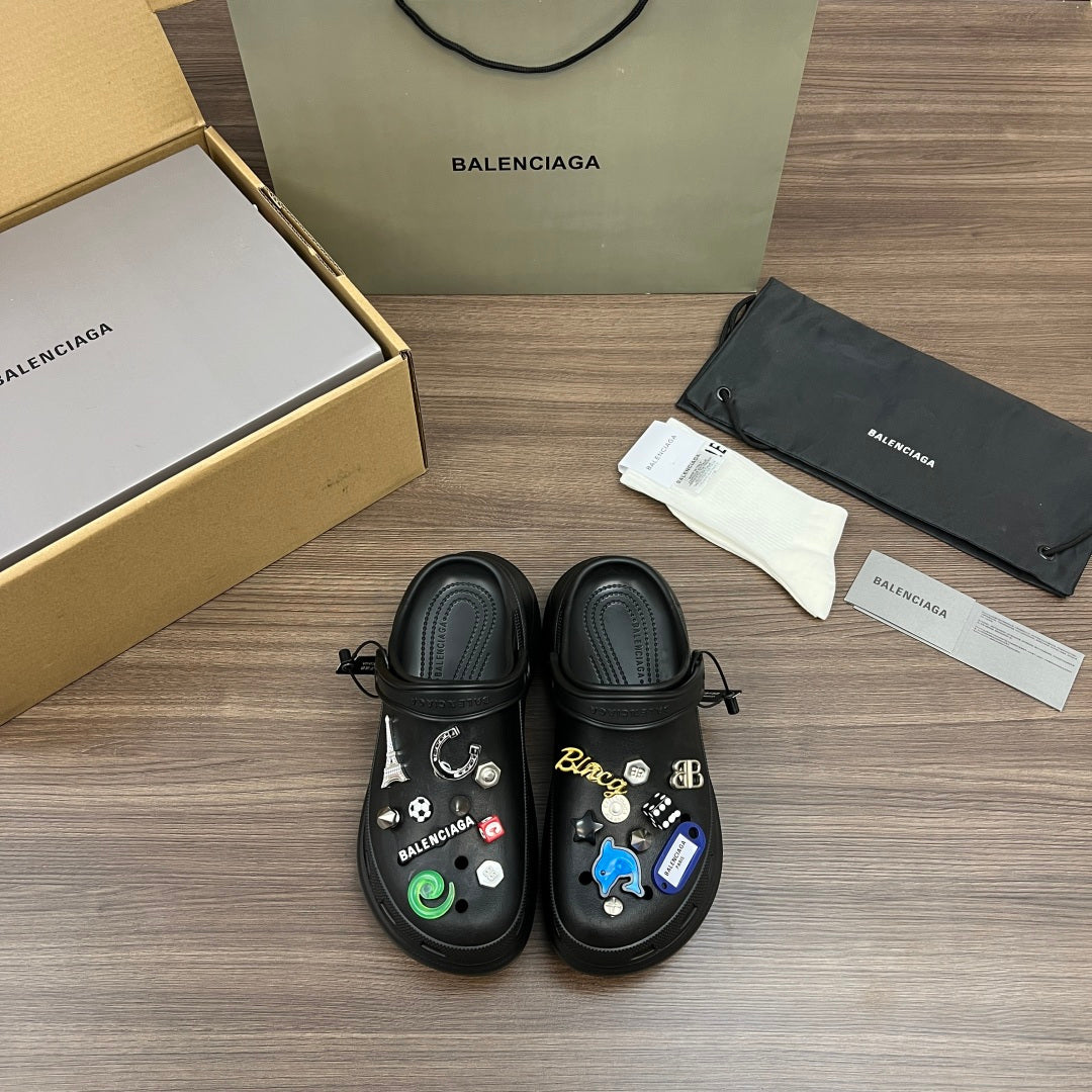 Black Balenciaga sandals with lace-up straps and decorative charms on top