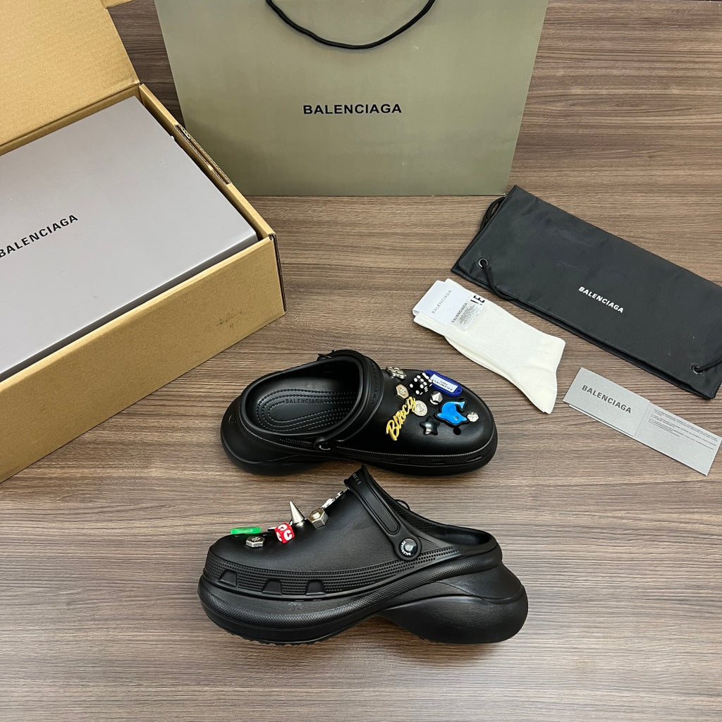Black Balenciaga sandals with decorative charms and strap detail, shown side angle