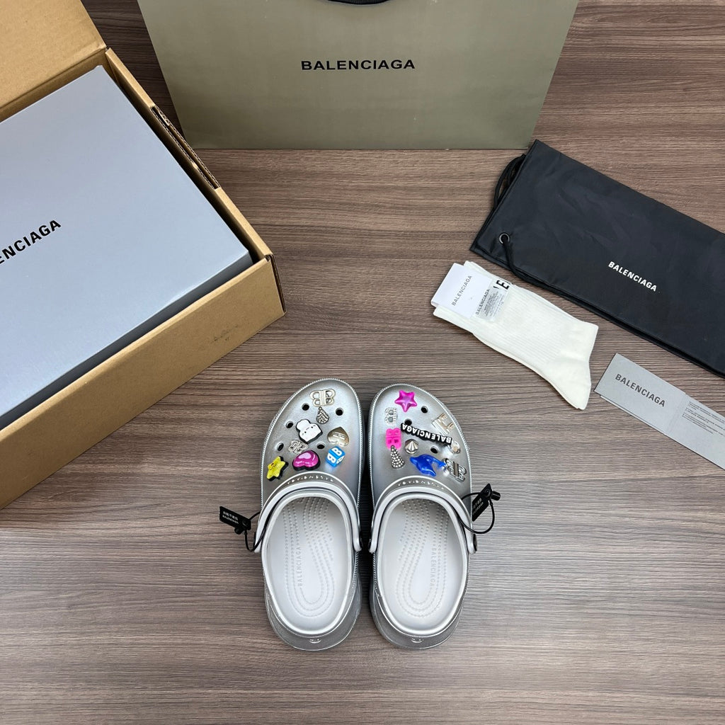 Balenciaga silver platform clogs, heel view, with decorative charm accents