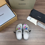 Balenciaga silver platform clogs, heel view, with decorative charm accents