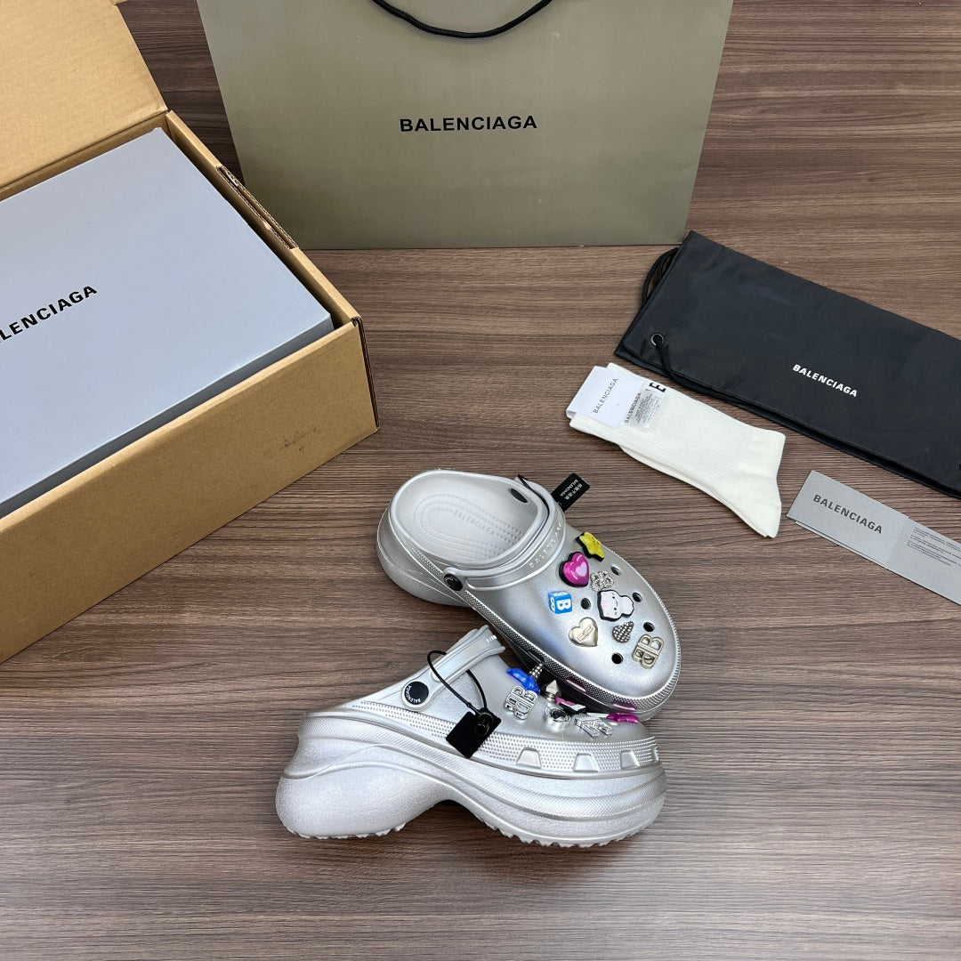 Balenciaga silver platform clogs, two-shoe view, with charm accessories