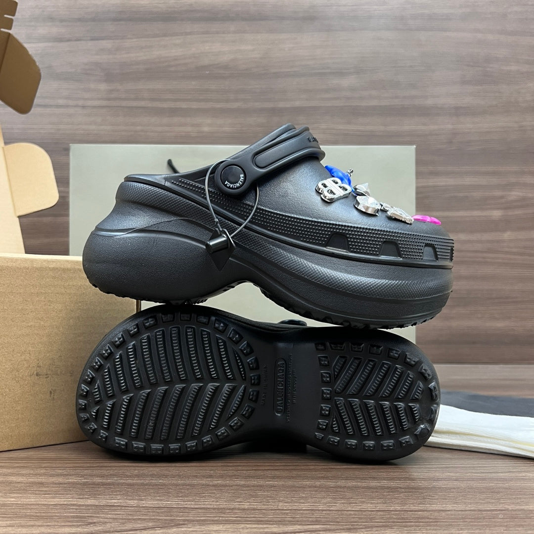 Black Balenciaga sandal clog with outsole treads visible and charm keyring on top