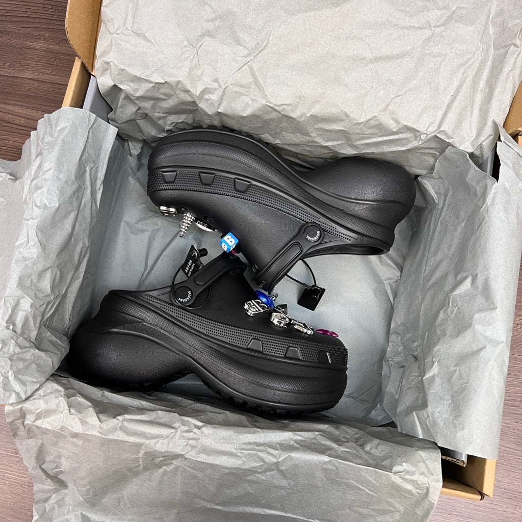 Black Balenciaga sandal clogs in open box with visible mesh texture and strap details