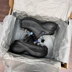 Black Balenciaga sandal clogs in open box with visible mesh texture and strap details