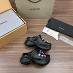 Black Balenciaga sandal clogs with small charm accessories on the top panels