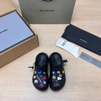 Black Balenciaga slide sandals with colorful charm patches and front straps