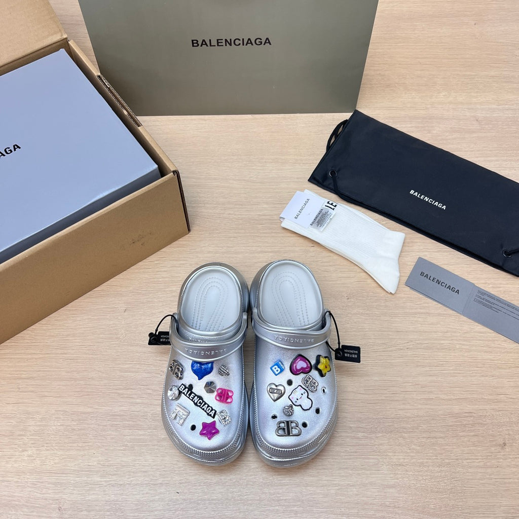 Silver slide clogs with open toe, ventilation holes, and colorful charm decorations