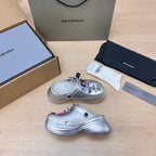 Silver clog with open toe, ventilation holes, and colorful charm keychain accents