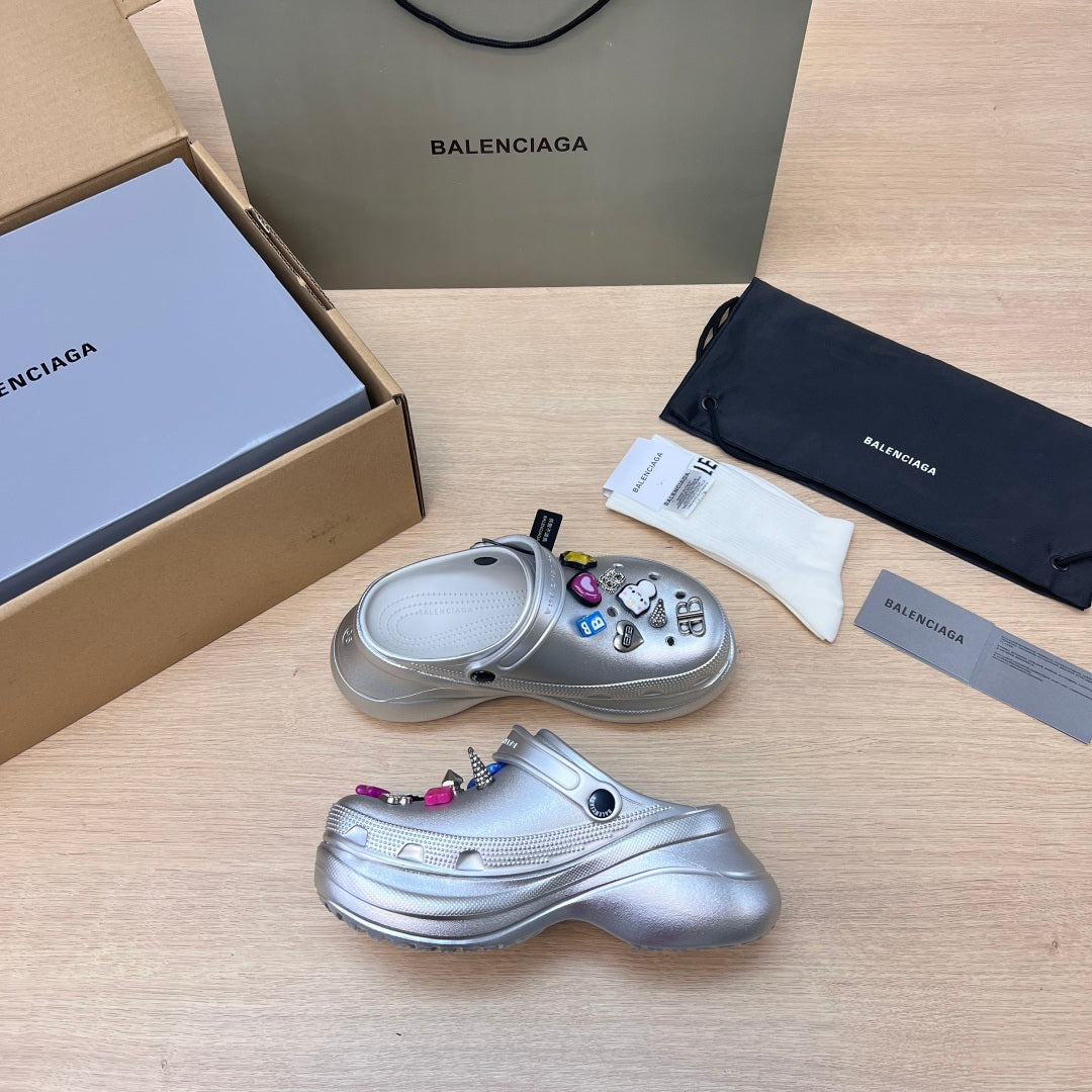 Silver clog with open toe, ventilation holes, and colorful charm keychain accents