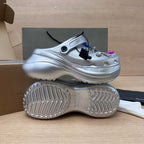 Silver clog sole view with textured tread and open toe upper with charm accents