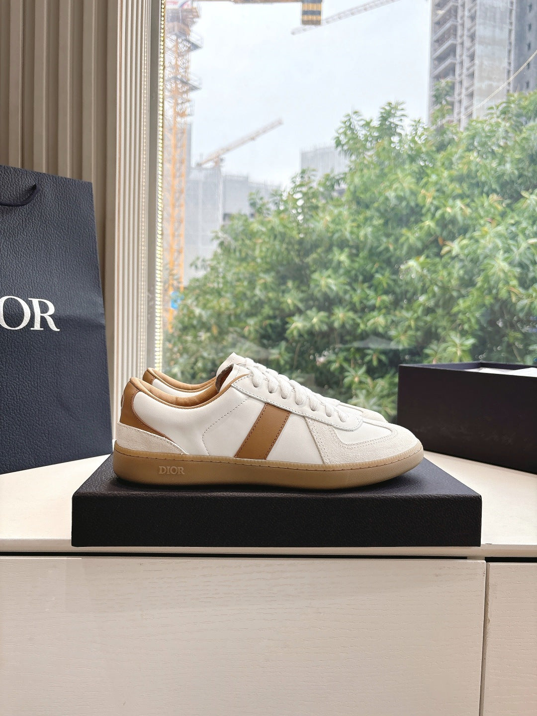 White and tan unisex sneakers, side profile on display box