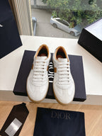 White and tan unisex sneakers facing forward, lace-up front