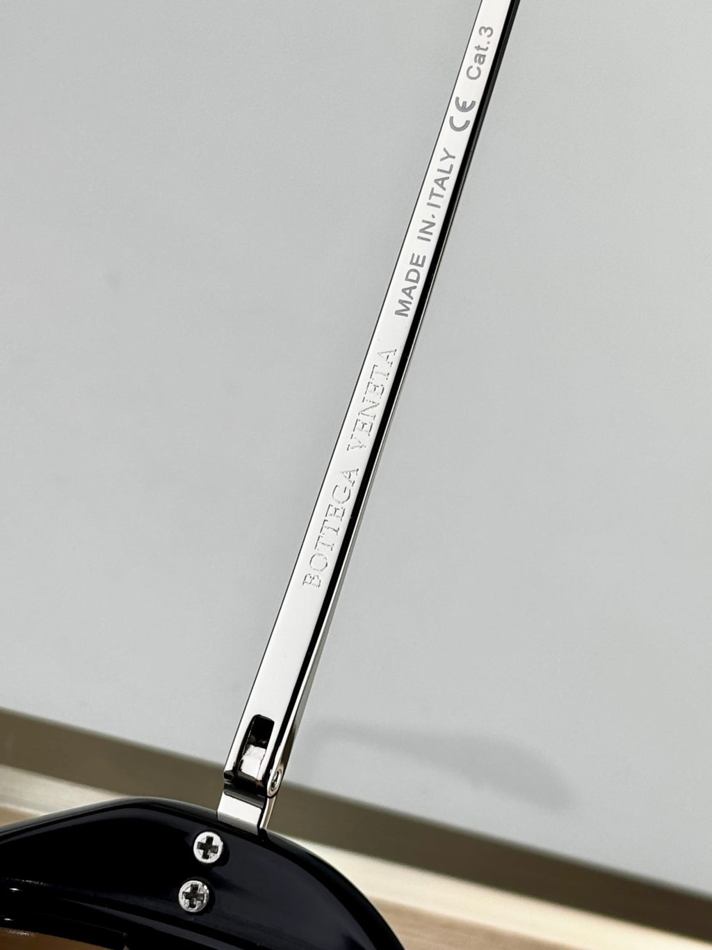 Sunglasses arm close-up with “MADE IN ITALY & CA C3” text on the metal