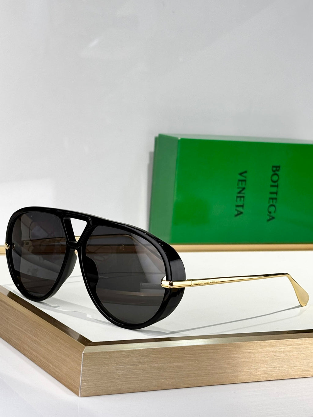 Black cat-eye sunglasses with dark lenses and gold-tone metal arms