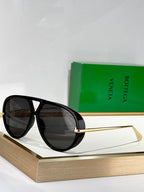 Black cat-eye sunglasses with dark lenses and gold-tone metal arms