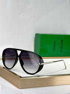 Black cat-eye sunglasses with dark lenses and thin gold-tone metal arms