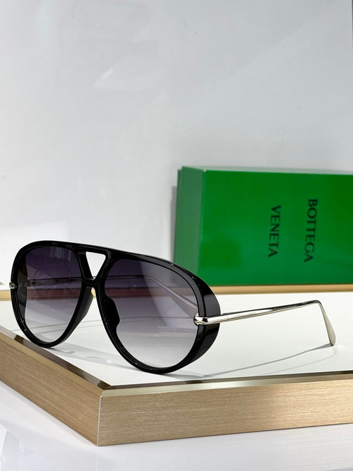 Black cat-eye sunglasses with dark lenses and thin gold-tone metal arms