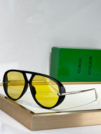 Black sunglasses with yellow lenses and gold-tone metal arms