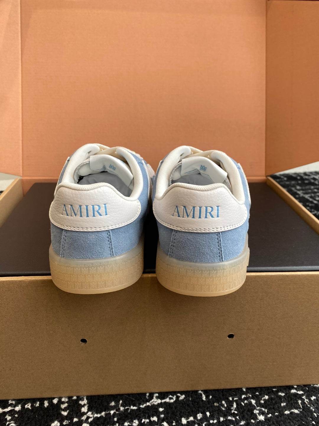 Light blue sneakers with white heel counter and AMIRI lettering on the back
