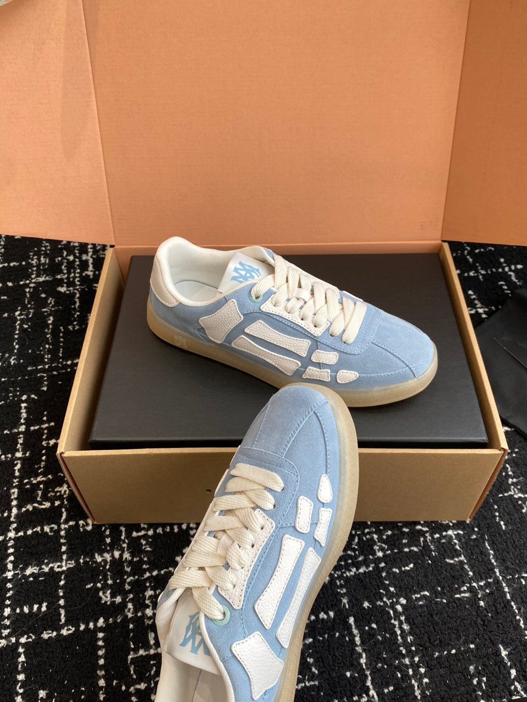 Light blue low-top sneakers with white laces and a textured rubber sole