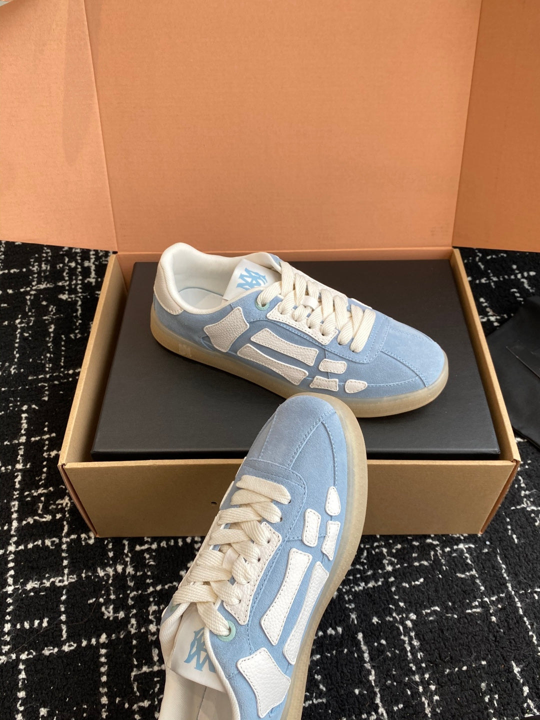 Light blue low-top sneakers with white laces and a textured rubber sole