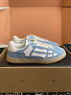 Light blue low-top sneakers with white laces and contrast logo patches