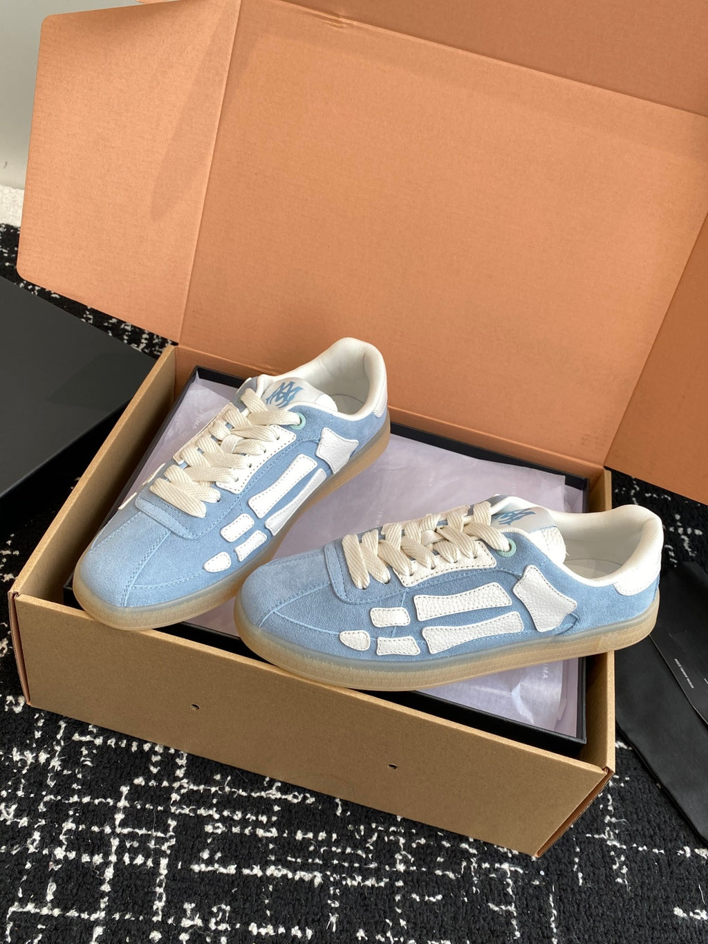 Light blue low-top sneakers with white laces and white logo side stripe details