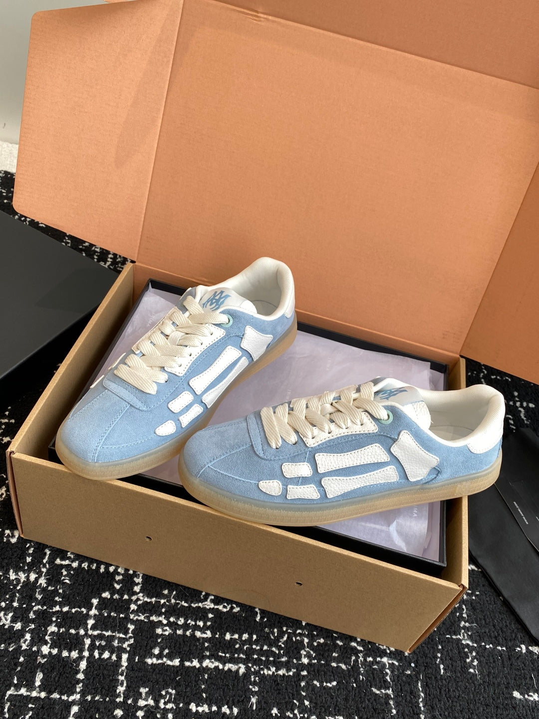 Light blue low-top sneakers with white laces and white logo side stripe details