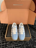 Light blue and white low-top sneakers with white laces, displayed in shoe box