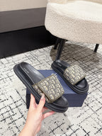 Dior slide sandals pair with beige logo straps and black platform soles