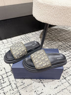 Dior slide sandals with beige patterned straps and black platform soles