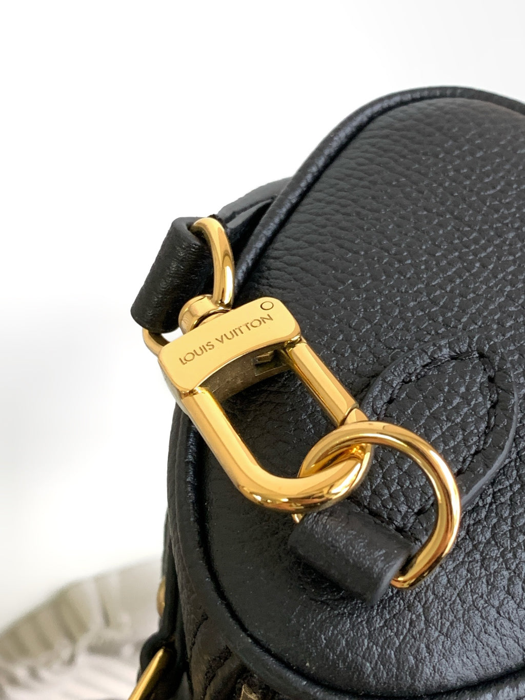 Louis Vuitton black leather bag clasp with gold hardware and side tab detail