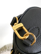 Louis Vuitton black leather bag clasp with gold hardware and side tab detail