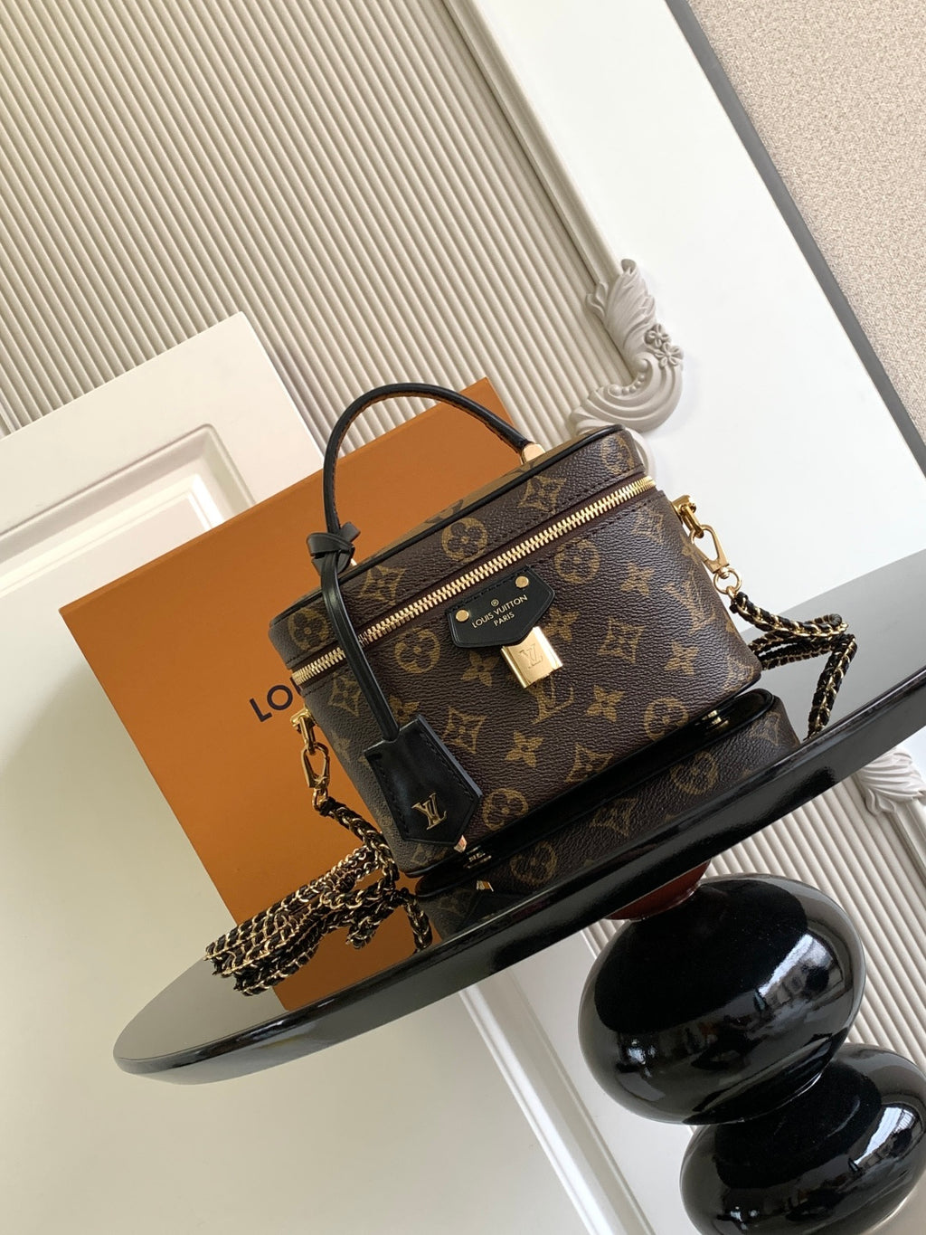 Louis Vuitton monogram mini bag with top handle and chain strap, gold zipper hardware.