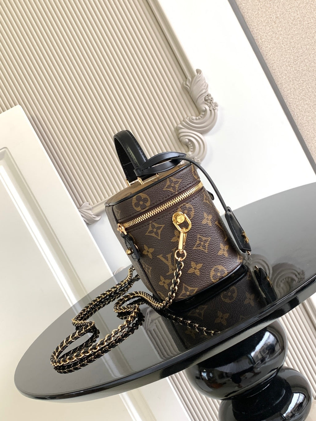Louis Vuitton monogram mini bag with black top handle, gold zipper and chain strap.