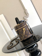 Louis Vuitton monogram mini bag with black top handle, gold zipper and chain strap.