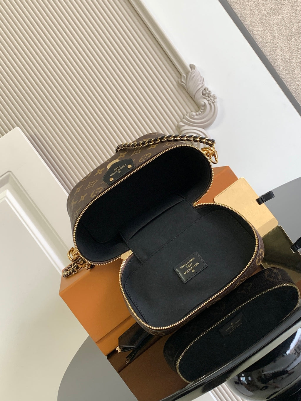Louis Vuitton monogram mini bag open, showing black interior lining and top zipper closure.