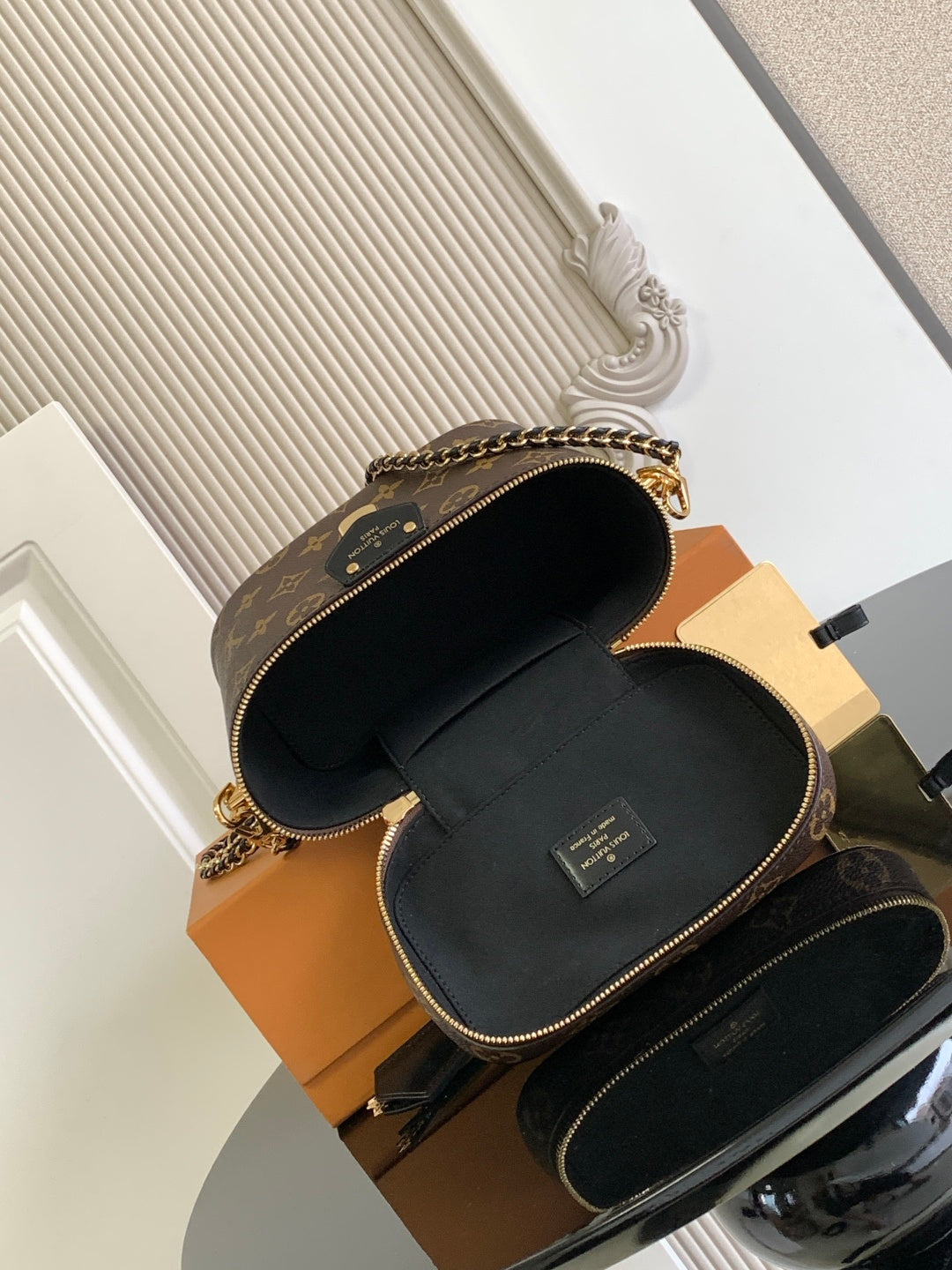 Louis Vuitton monogram mini bag open, showing black interior lining and top zipper closure.