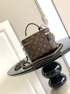 Louis Vuitton monogram mini handbag with top handle, gold zipper, and chain shoulder strap.