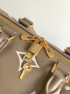 Louis Vuitton bag close-up: taupe leather, gold zipper pull and charm keyfob